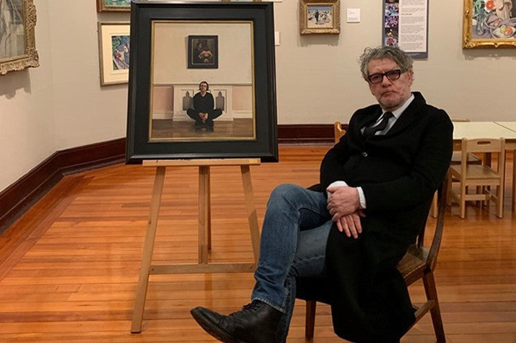 Jack Vettriano sitting in front of one of his artworks 